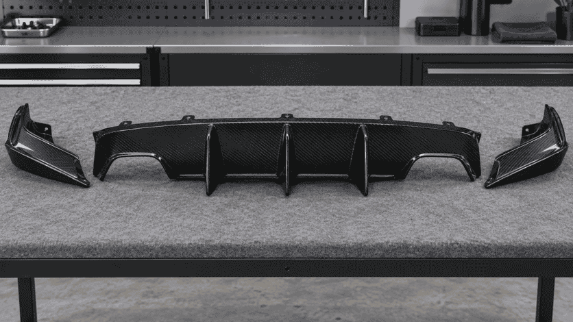 Concept view of a carbon rear diffuser panel and separate corner pieces on a workbench