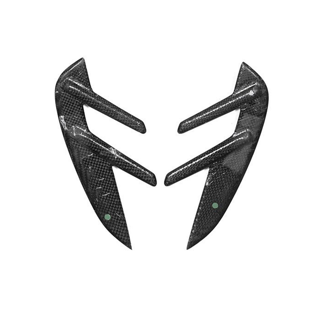 Two compact fender vent trim pieces with projecting fins.