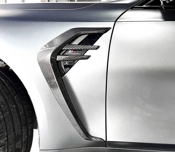 Close view of patterned fender trim on a silver vehicle.