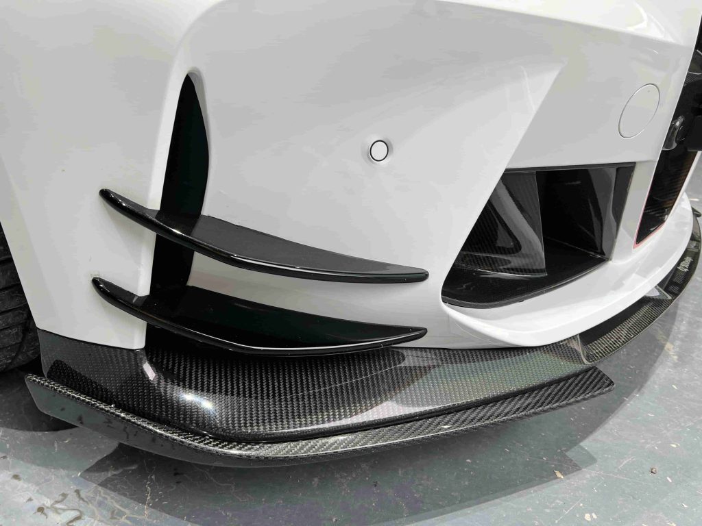 Close view of bumper canards above a front lip.