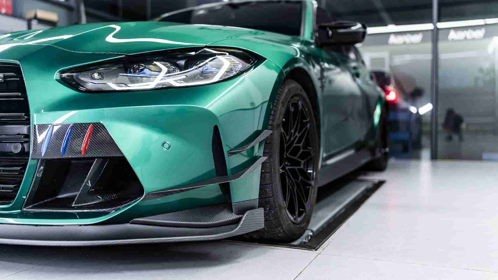 Front-quarter view of a green BMW with bumper styling.