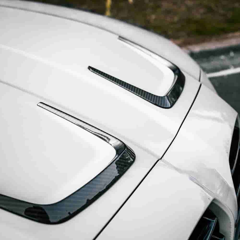 Close view of a U-shaped trim piece on a white hood.