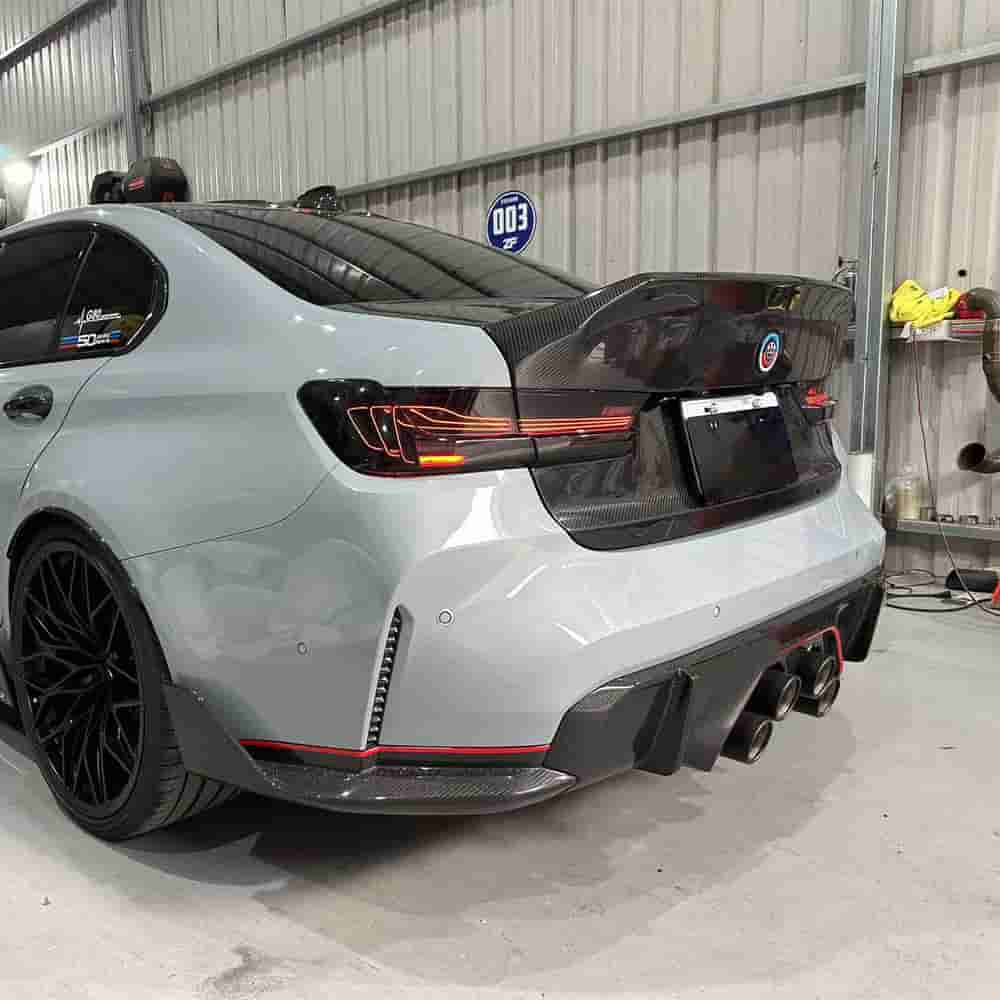 Rear-quarter view of a gray BMW with central exhaust outlets.