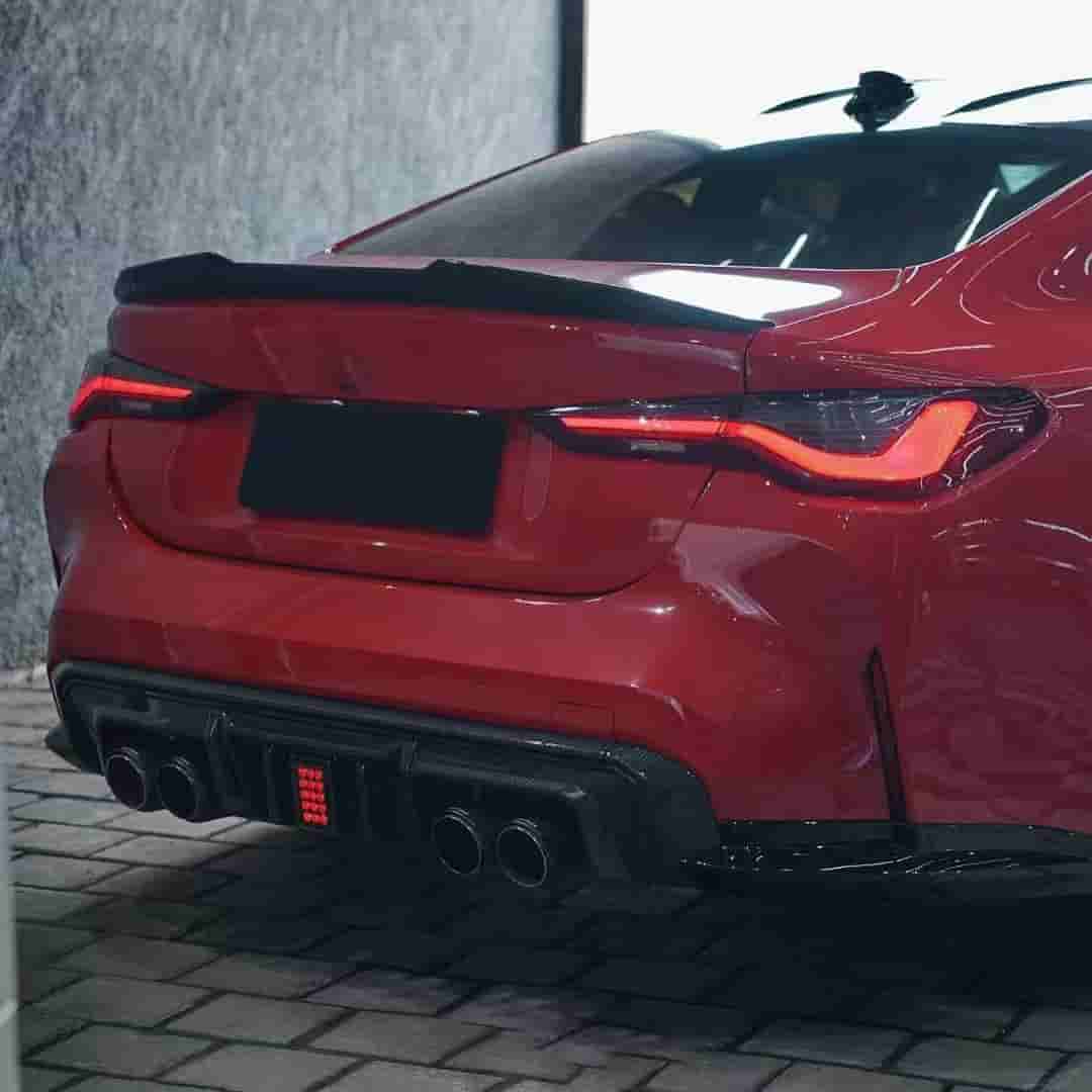 Rear-quarter view of a red BMW with diffuser styling.