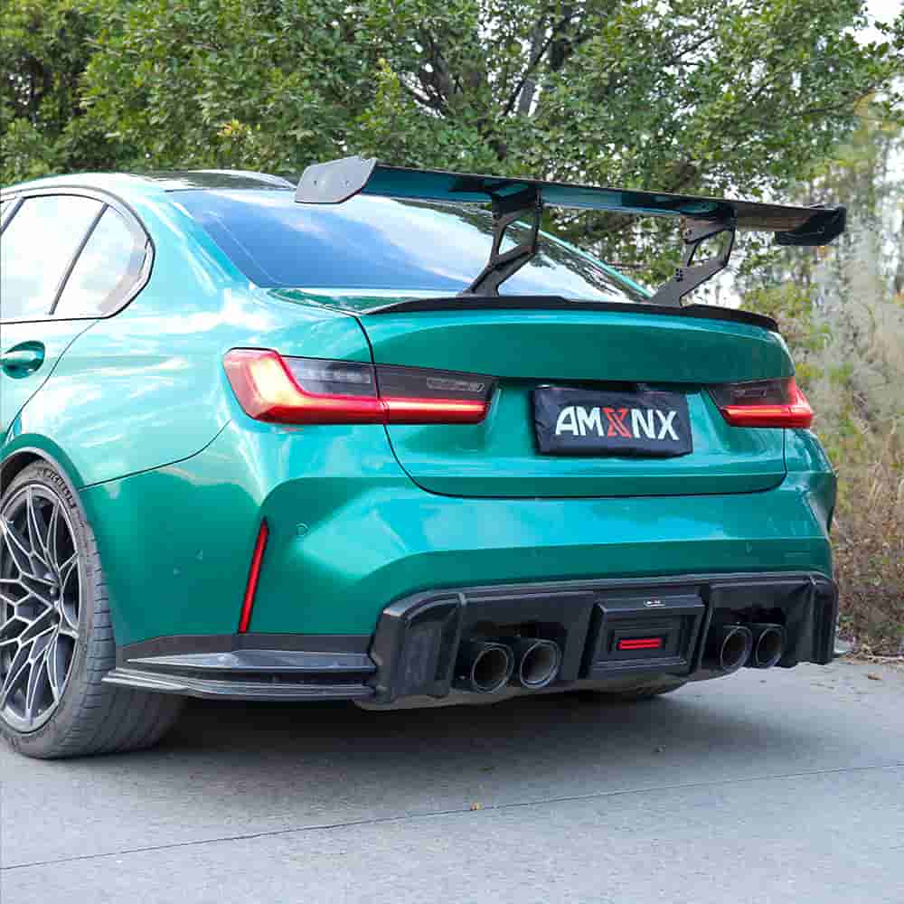 Rear-quarter view of a green sedan with a rear wing and diffuser.