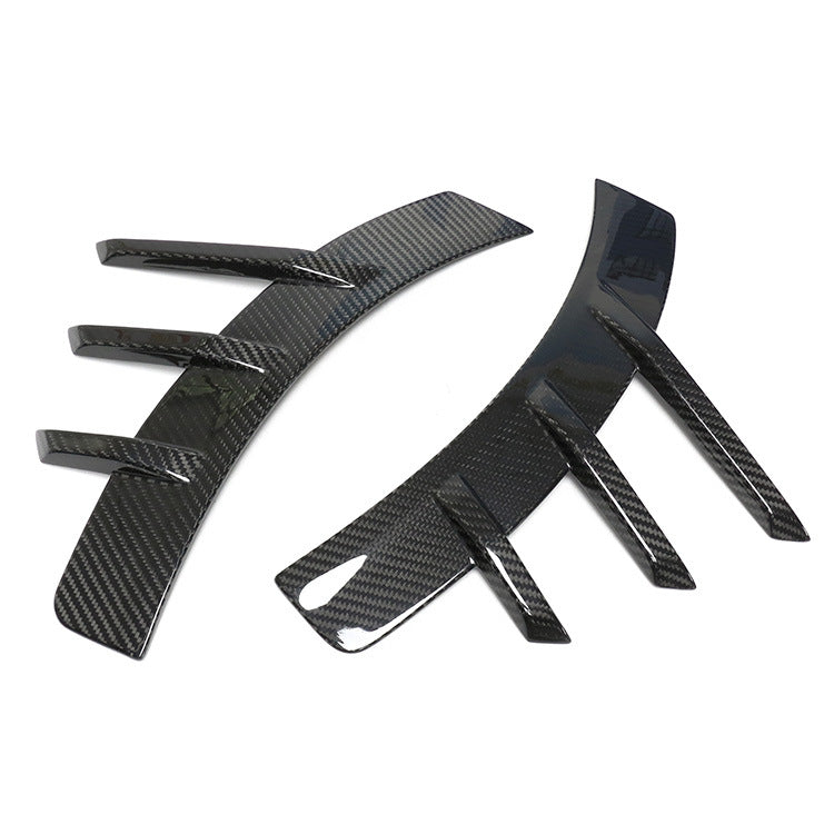 Pair of curved fender trim pieces with projecting fins.