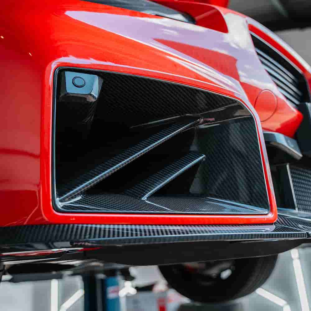 Close view of a diagonal-bar vent on a red bumper.