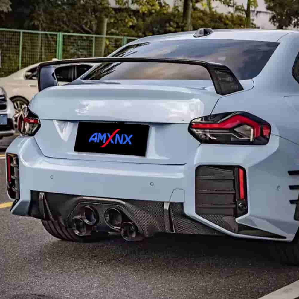 Rear view of a light-colored BMW with a trunk spoiler.