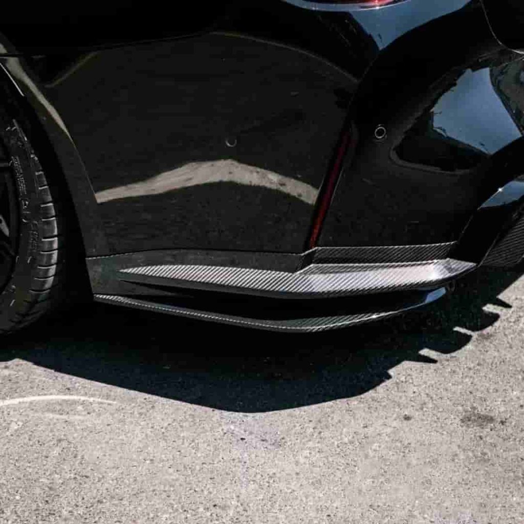 Close view of rear bumper corner styling near a wheel.