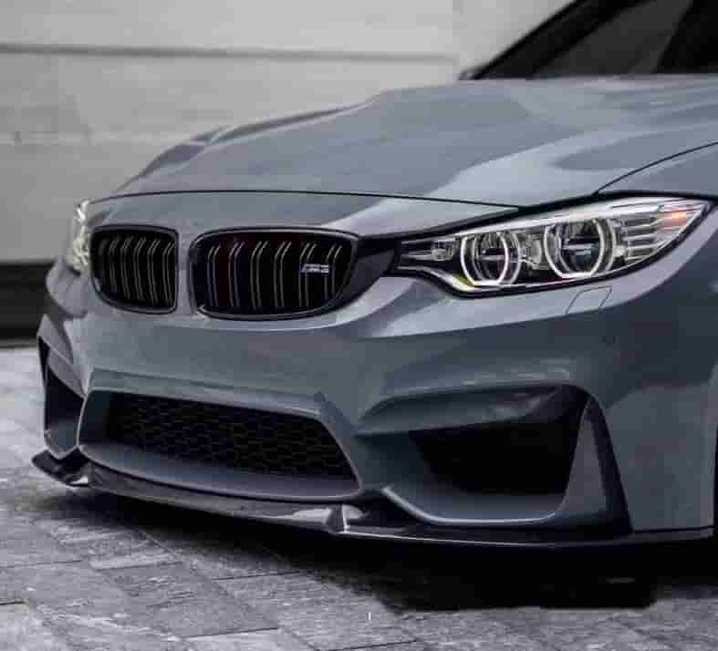 Close front-quarter view of a gray BMW with a front lip.