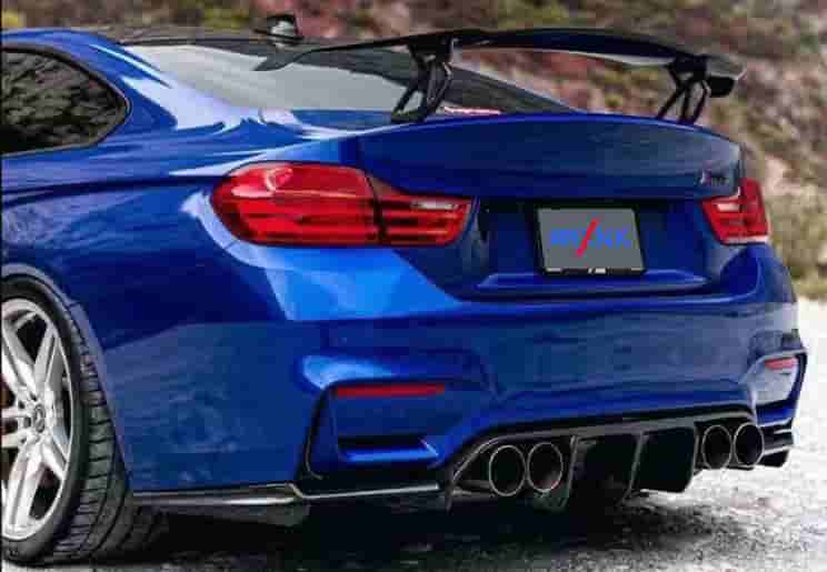 Rear-quarter view of a blue coupe with a rear wing and diffuser.