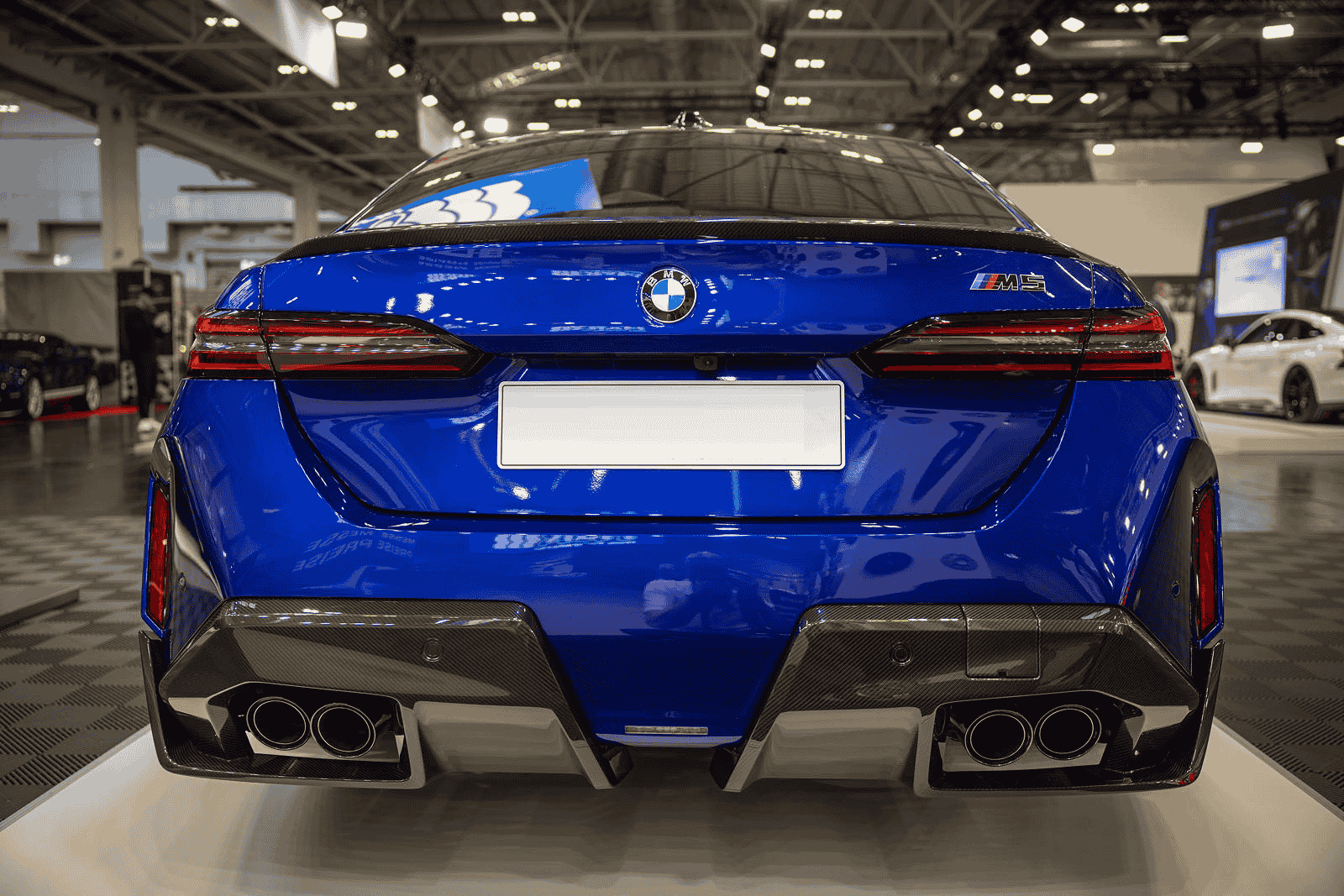 Rear view of a blue BMW showing exhaust and bumper styling.
