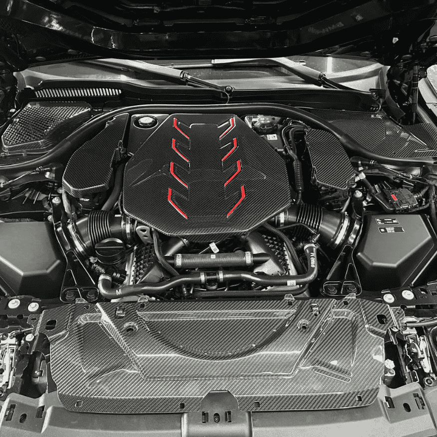 Wide engine-bay view showing trim around a central cover.