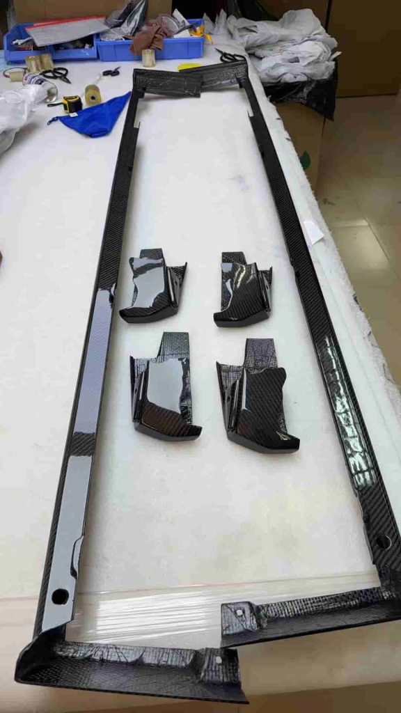 Long side trim components and smaller pieces arranged on a workshop surface.