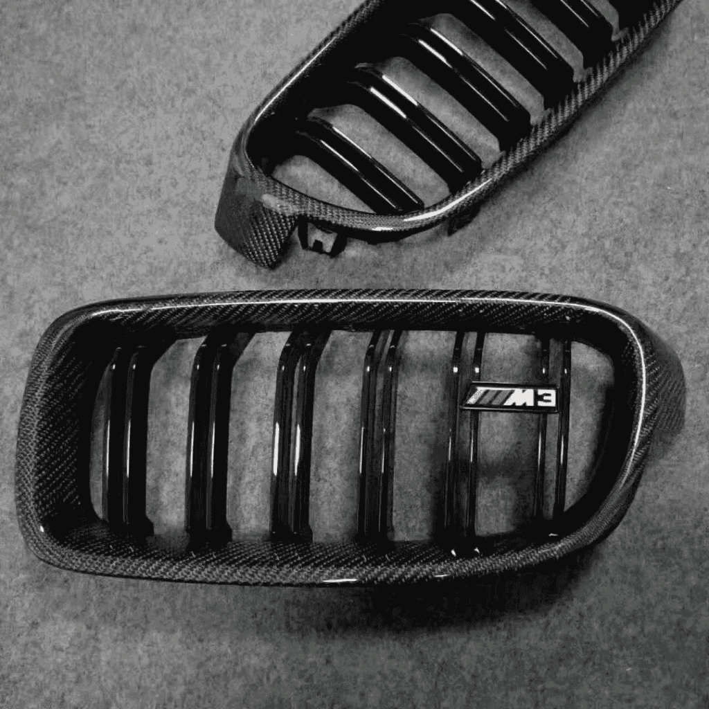 Pair of dark kidney grilles on a workshop surface.