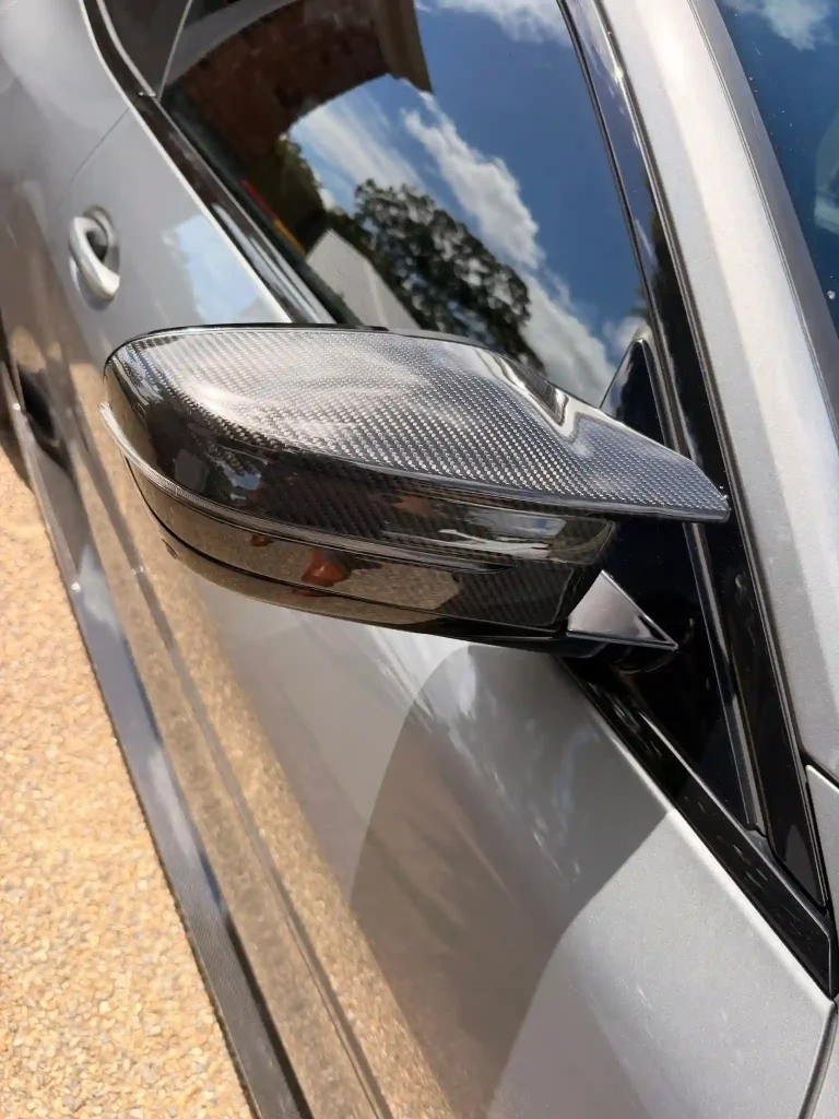 Customer photo of a carbon fiber mirror cap installed on a silver BMW.